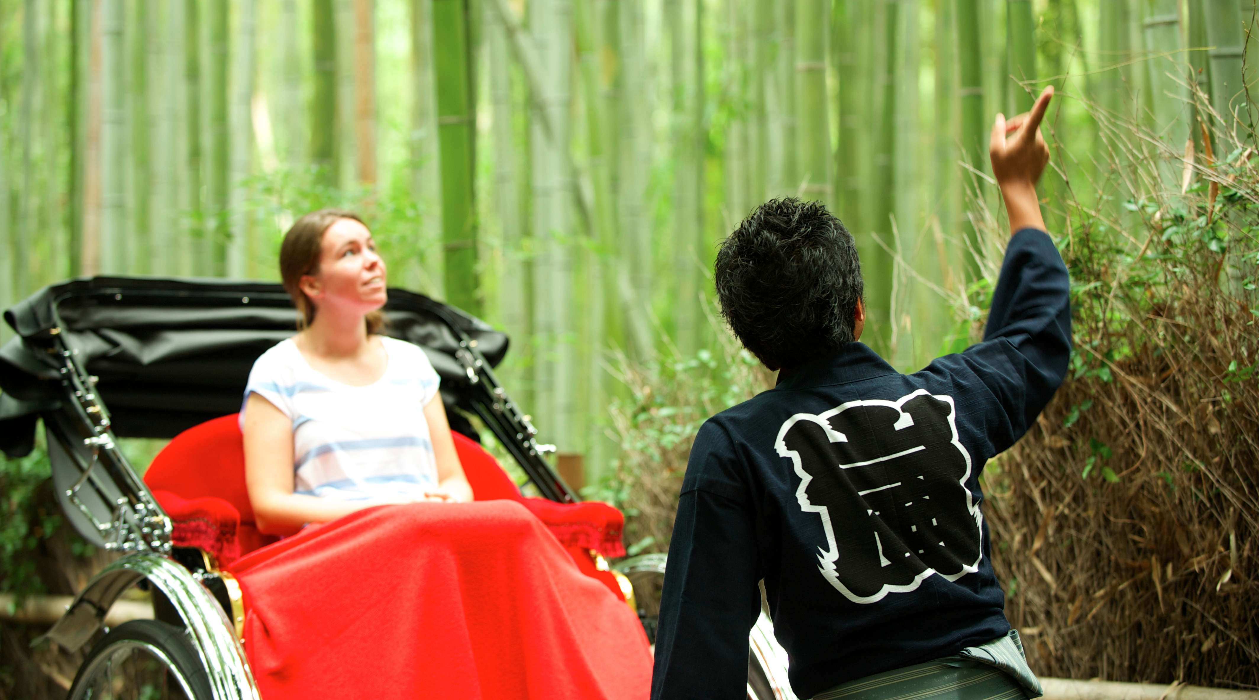 Traditional rickshaw carrying guests through the Arashiyama bamboo grove in Kyoto